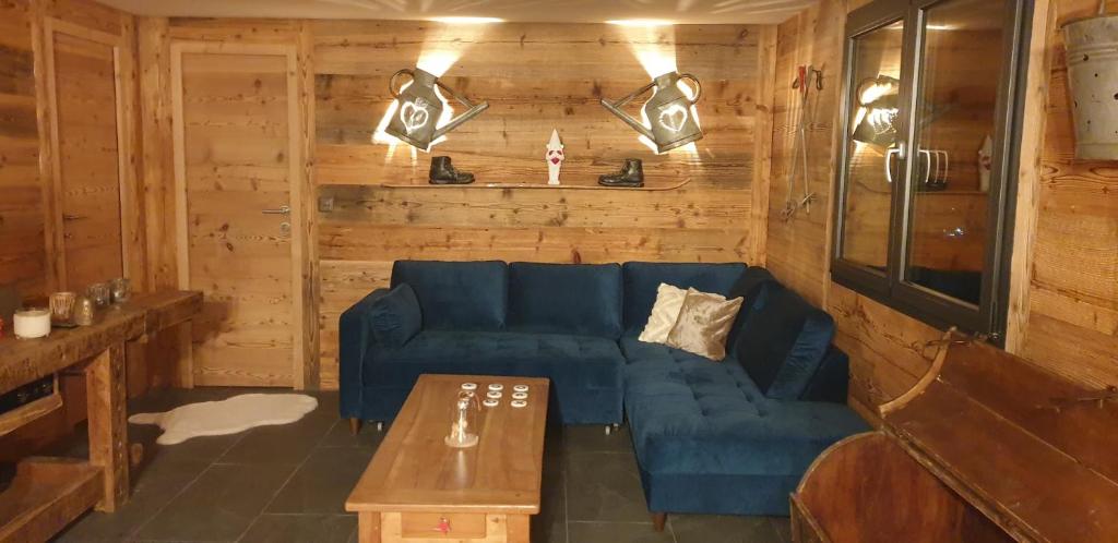 a living room with a blue couch and a table at Chalet le Grenier des Crosets in Champéry