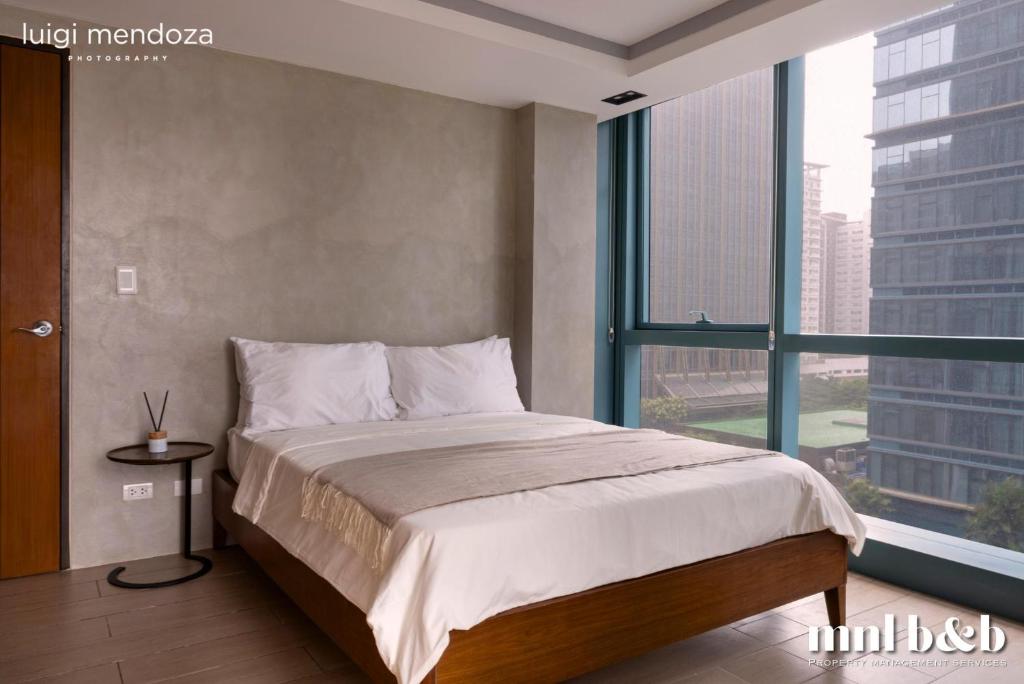 een slaapkamer met een bed en een groot raam bij Luxury 2BR in Uptown Bgc -- Free pool use -- in Manilla