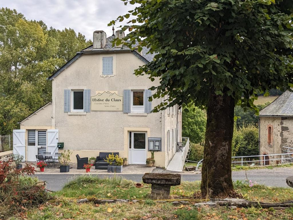 un edificio con un árbol delante de él en L'Estive du Claux en Le Claux