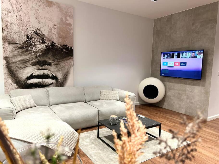 uma sala de estar com um sofá e uma televisão em BS Apartment 2 em Durrës