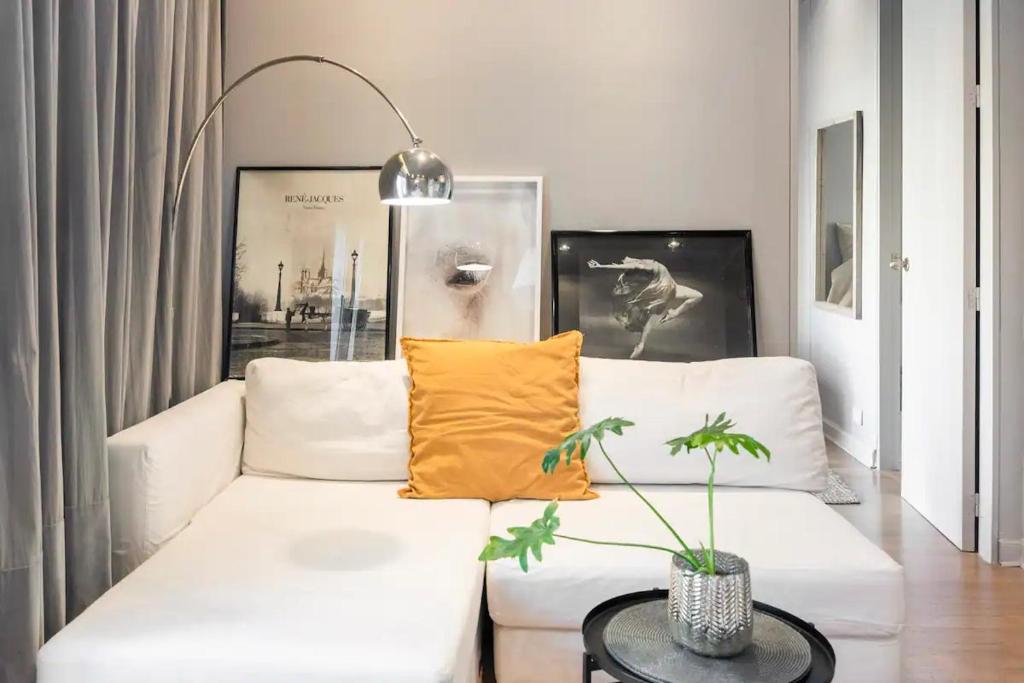 una sala de estar con un sofá blanco con almohadas amarillas en Hermoso departamento en el corazón de la Recoleta en Buenos Aires