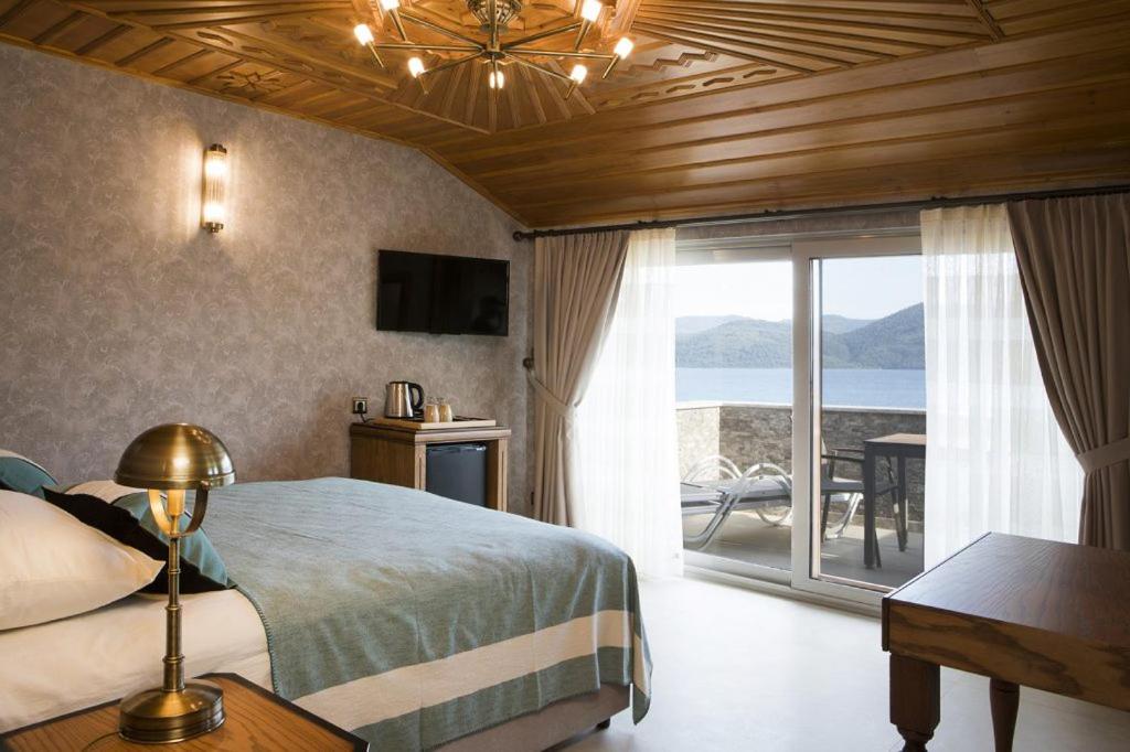 a bedroom with a bed and a view of the ocean at GÖKTÜRK OTEL in Muğla