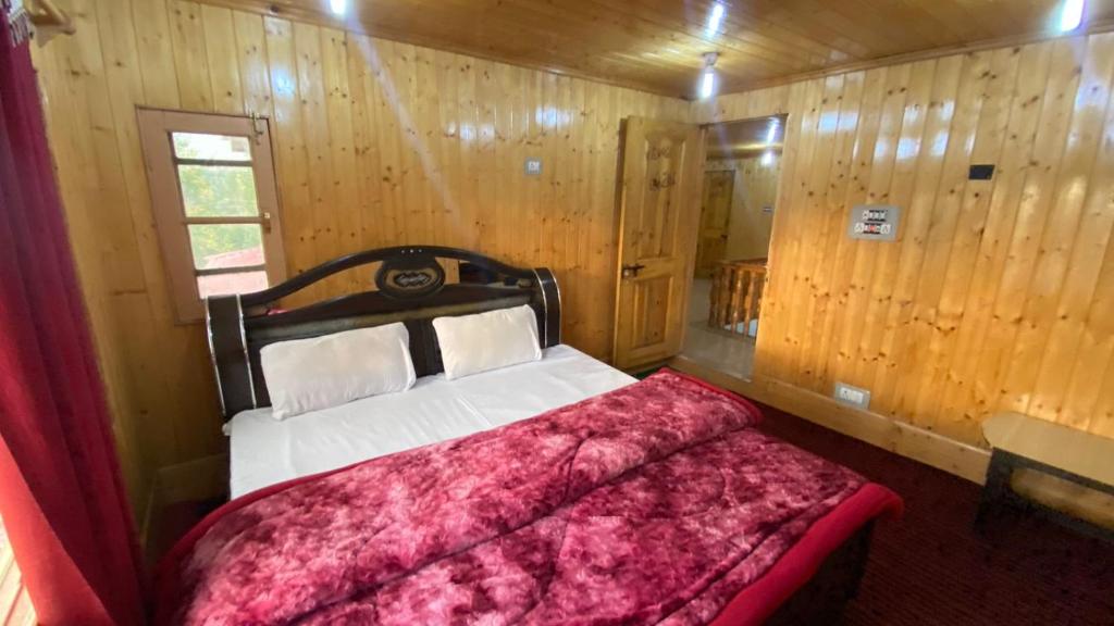 een slaapkamer met een bed in een kamer met houten wanden bij The Sarwah, Stay Blessed! Hotel and Restaurant in Tangmarg