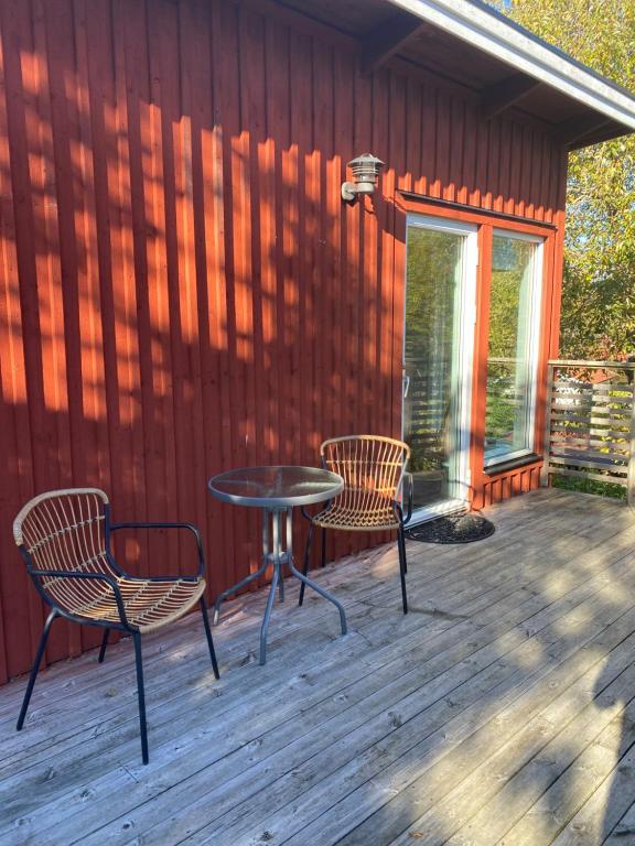 eine Terrasse mit 2 Stühlen und einem Tisch auf einer Terrasse in der Unterkunft Sigridsro in Alingsås