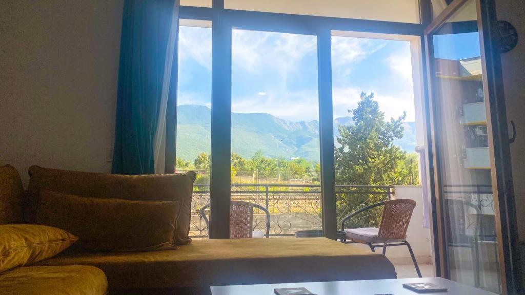 sala de estar con sofá y ventana grande en Smart Lugano Apartment, en Tirana