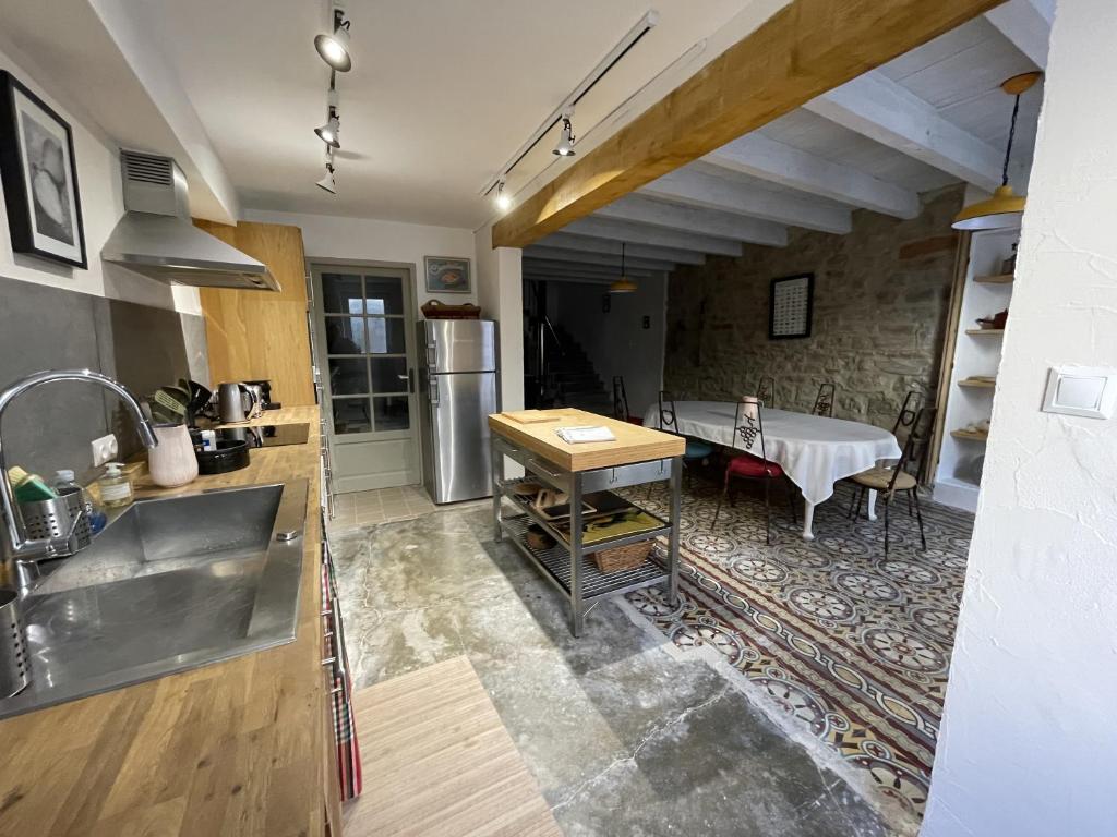 a kitchen with a sink and a table at Le Taurillou 