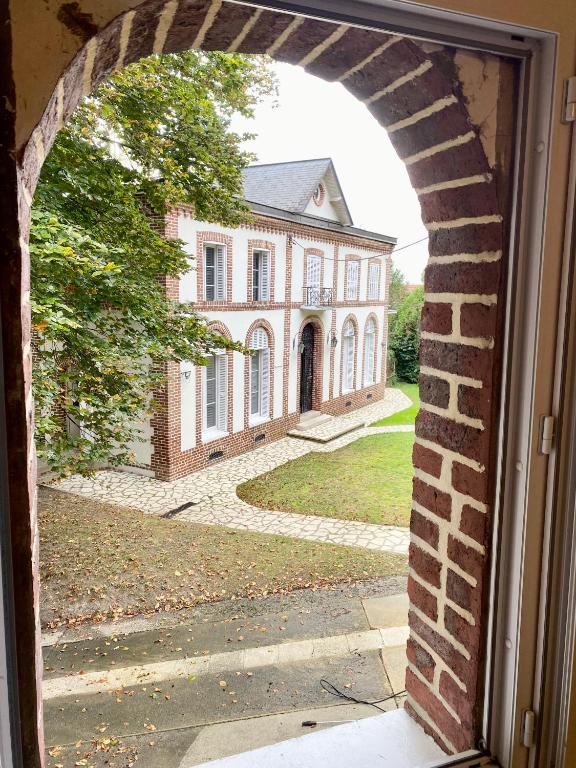 une arche devant un bâtiment en briques dans l'établissement Maison Voltaire, à Bonsecours