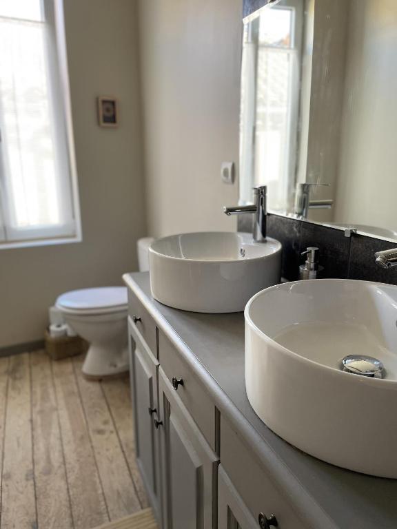 a bathroom with two sinks and a toilet at Le Taurillou 