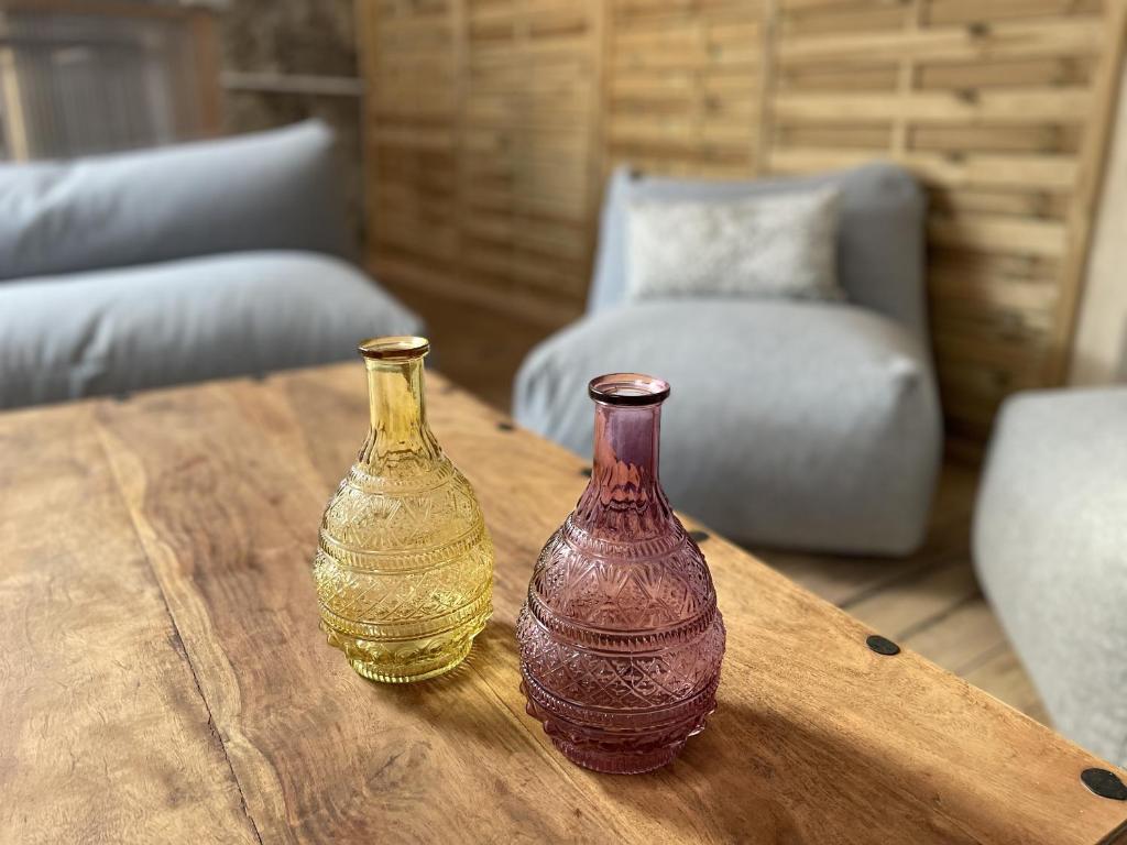 two glass vases sitting on a wooden table at Le Taurillou 
