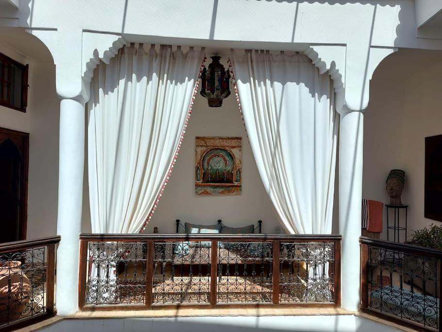 a balcony with white curtains and a railing at Riad Sophora - Peaceful Heaven in Marrakech in Marrakesh