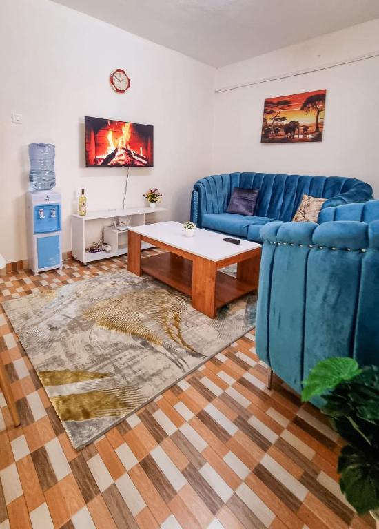 - un salon avec un canapé bleu et une table basse dans l'établissement Spacious 1br Fully Furnished with Parking Nakuru, à Nakuru