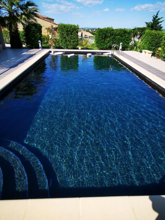une grande piscine avec de l'eau bleue dans l'établissement Rêve et Soleil, à Adissan