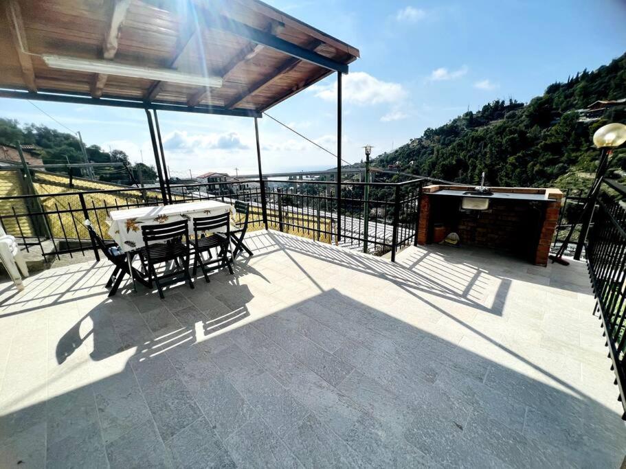 eine Terrasse mit einem Tisch und Stühlen auf dem Balkon in der Unterkunft Suite BBQ And Garden - Sanremo in Sanremo