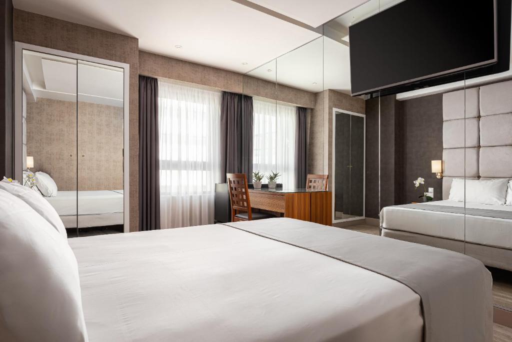 a hotel room with two beds and a desk at Lacoba Hotel in Athens