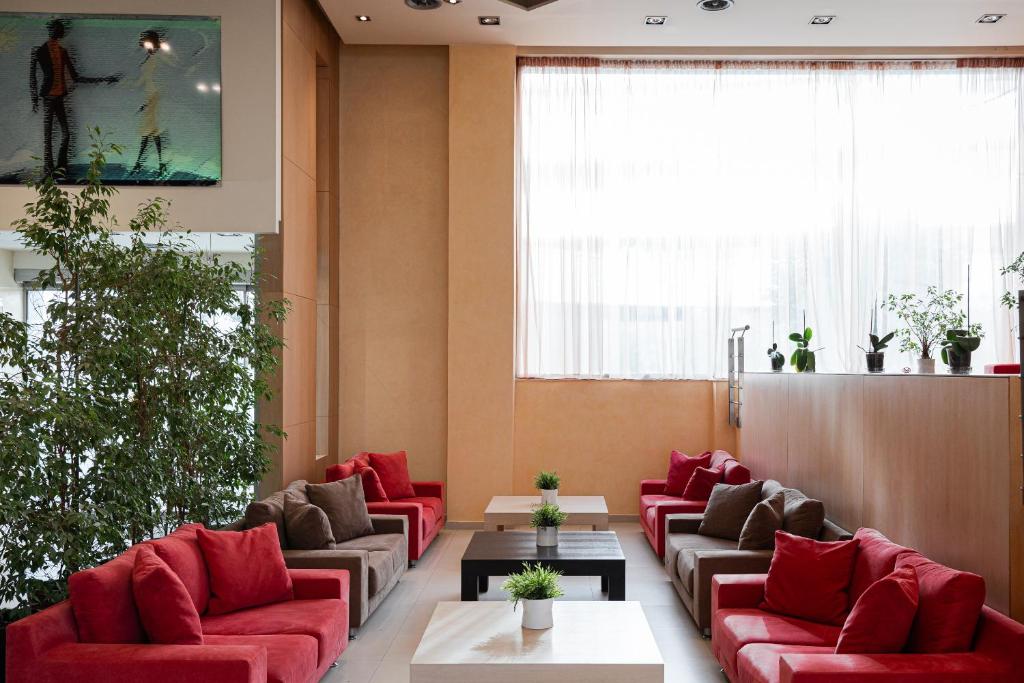 a waiting room with red furniture and a large window at Lacoba Hotel in Athens
