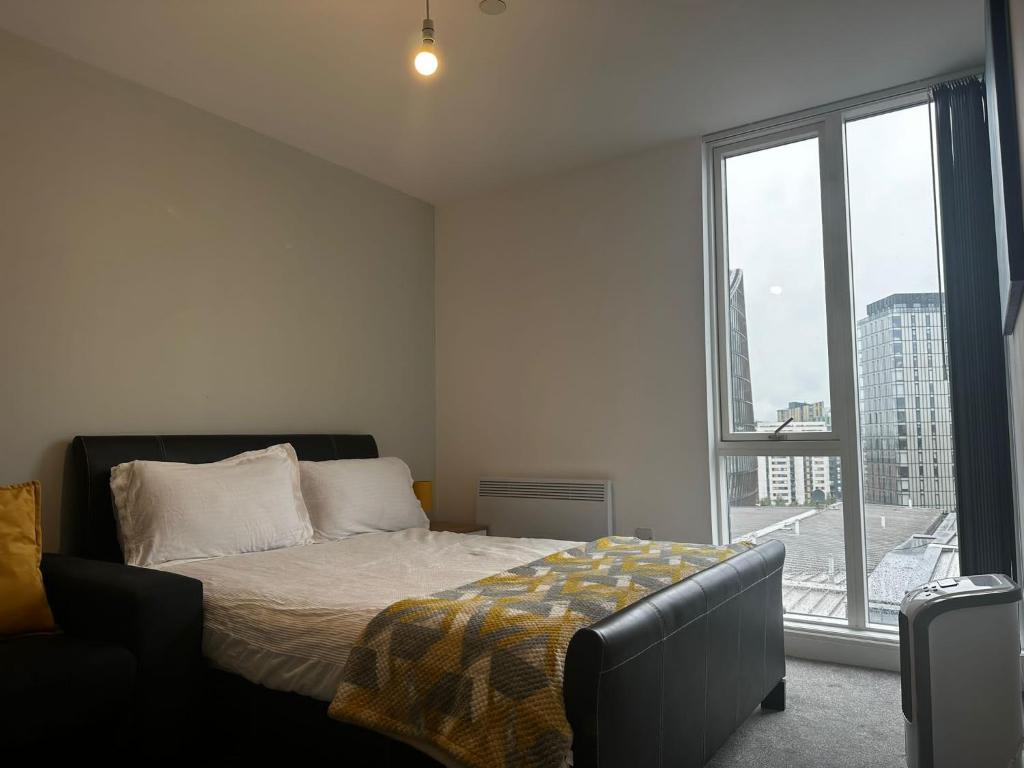 a bedroom with a bed and a large window at At home Property in Manchester