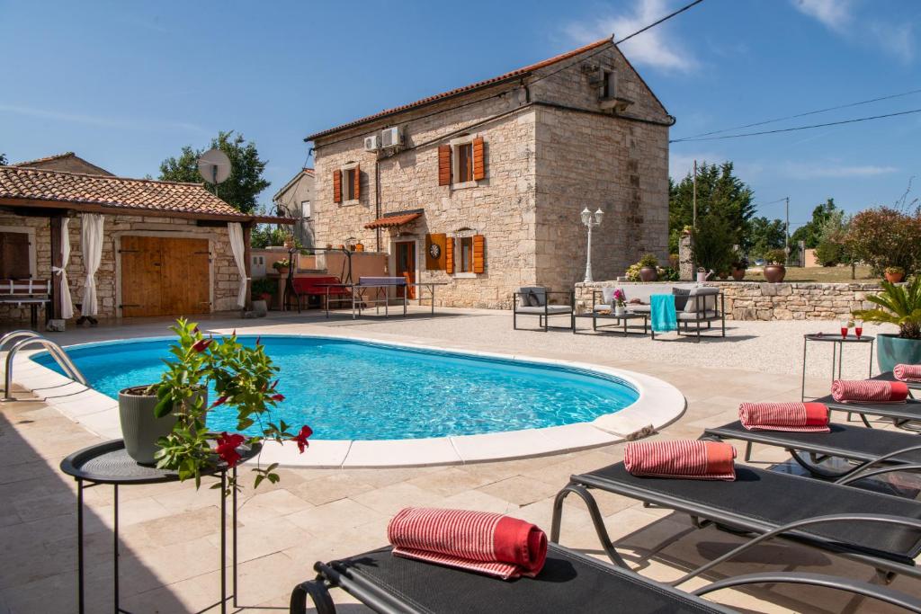 una piscina frente a una casa con sillas y un edificio en Villa Smolica en Krnica