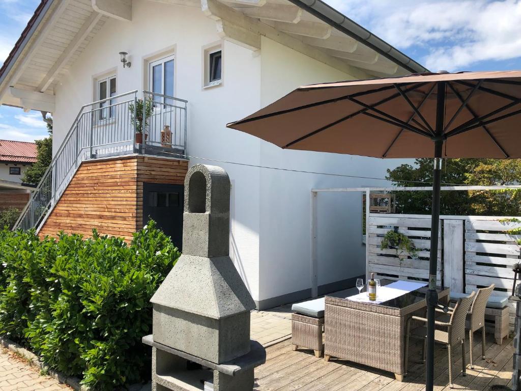 eine Terrasse mit einem Tisch und einem Sonnenschirm in der Unterkunft Ferienwohnung Chiemseezauber 