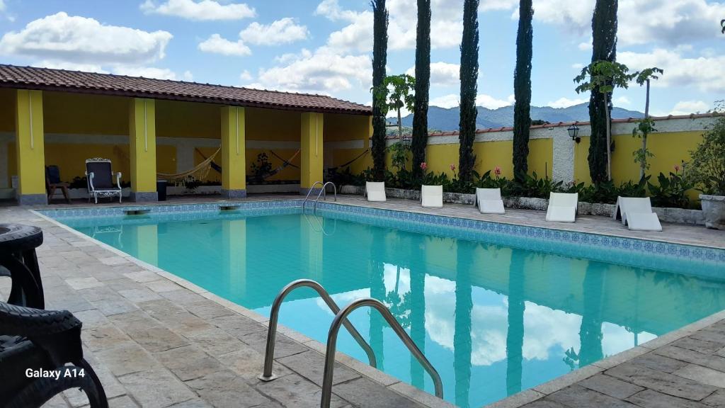 a swimming pool at a resort with palm trees at Hotel Ciconha in São Lourenço