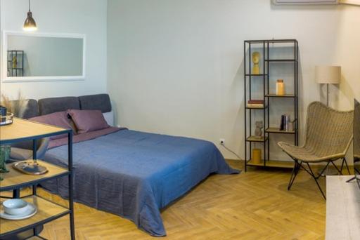 ein Schlafzimmer mit einem Bett, einem Tisch und einem Stuhl in der Unterkunft The Atelier in Burgas City