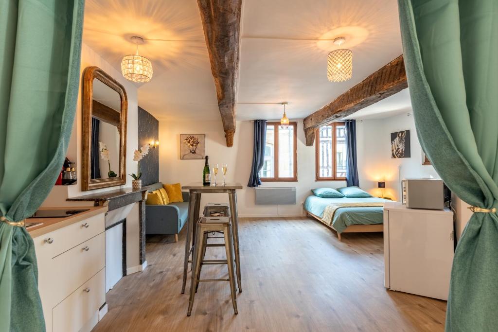 Habitación con cama y cocina con escritorio. en Le Romantique jacuzzi centre ville, en Rouen