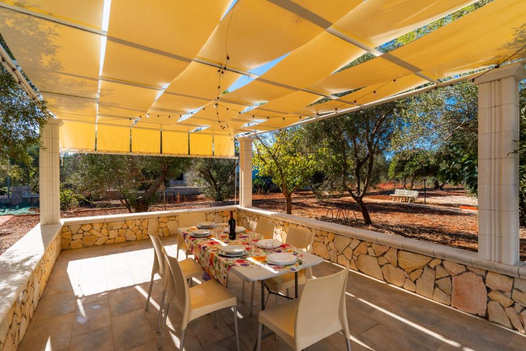 カストリニャーノ・デル・カーポにあるAppartamento Verde 1の石壁のパティオ(テーブル、椅子付)