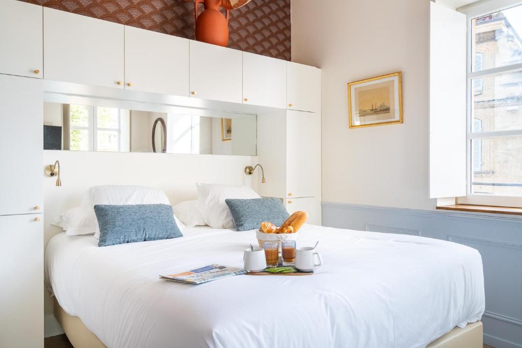 a bedroom with a white bed with a tray on it at La Réserve de Salon de Provence in Salon-de-Provence