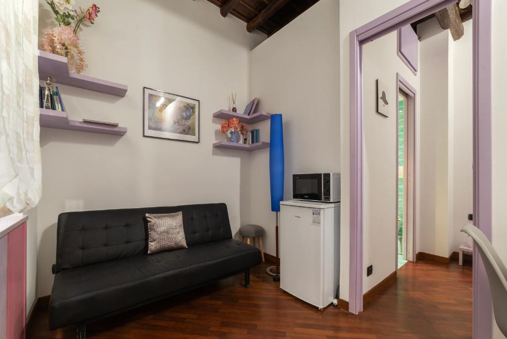 een woonkamer met een zwarte bank en een magnetron bij Lovely Apartment ad un passo da Piazza del Popolo! in Rome