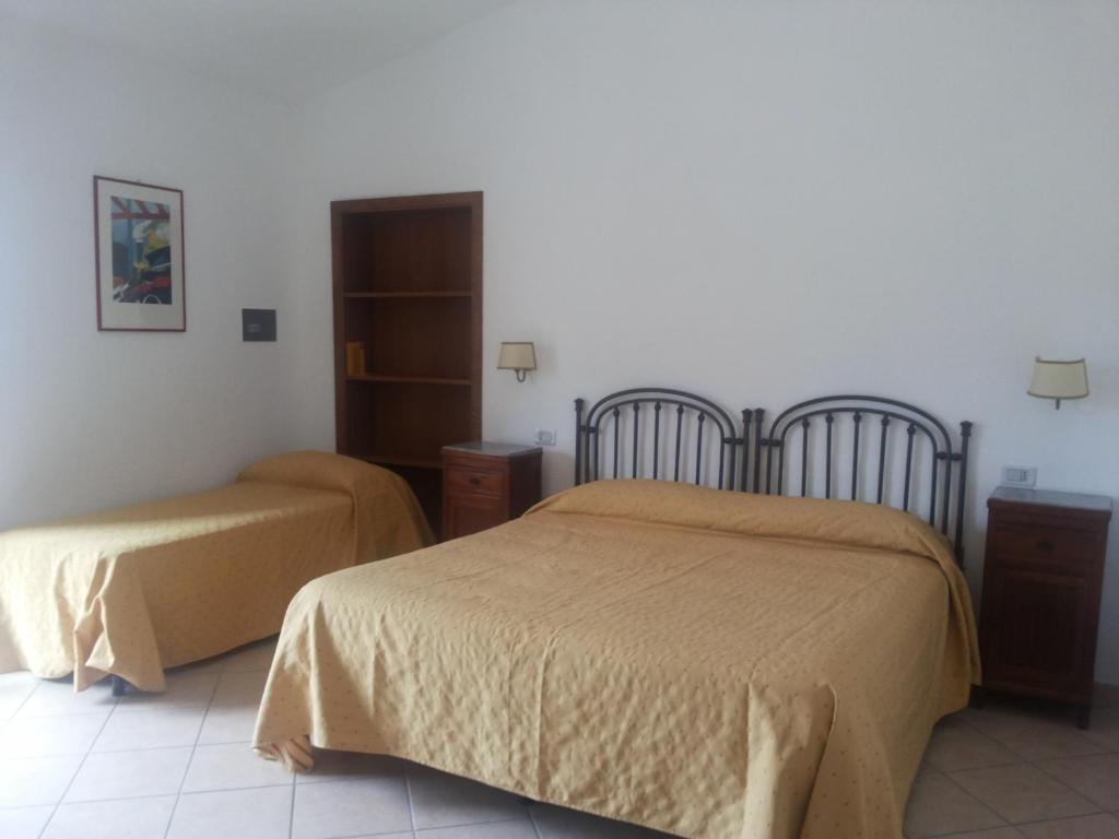 sypialnia z dwoma łóżkami i szafką w obiekcie Agriturismo La Mancosa w mieście Pollica