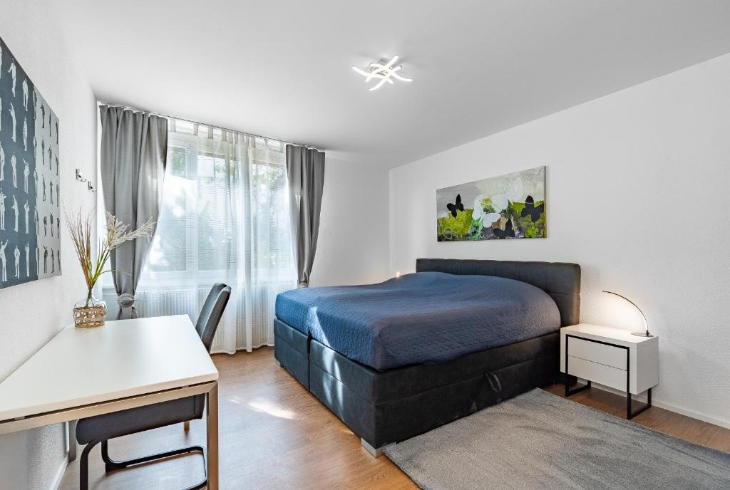 a bedroom with a bed and a desk and a window at Möblierte Zimmer - gratis Parkplatz in Bern