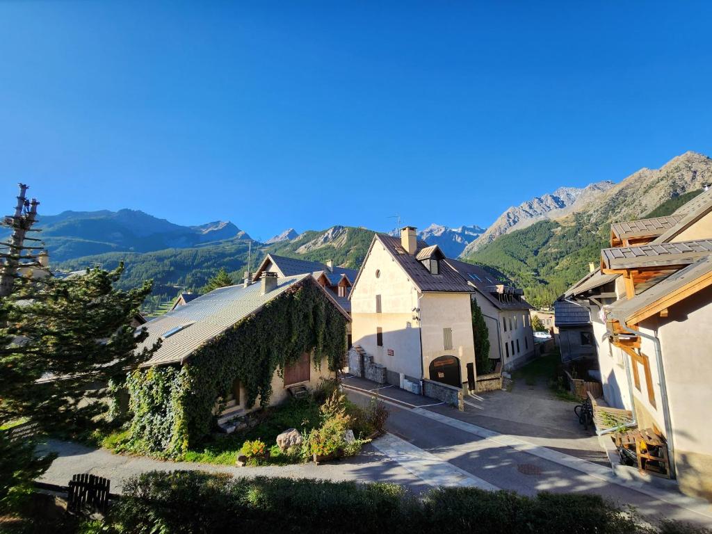 uma vista aérea de uma aldeia com montanhas ao fundo em La Petite Corneille - a chic and central studio. em Le Monêtier-les-Bains