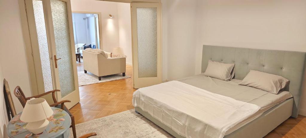 ein Schlafzimmer mit einem Bett, einem Stuhl und einem Tisch in der Unterkunft Luxury Apartment 3 Rooms in Bukarest