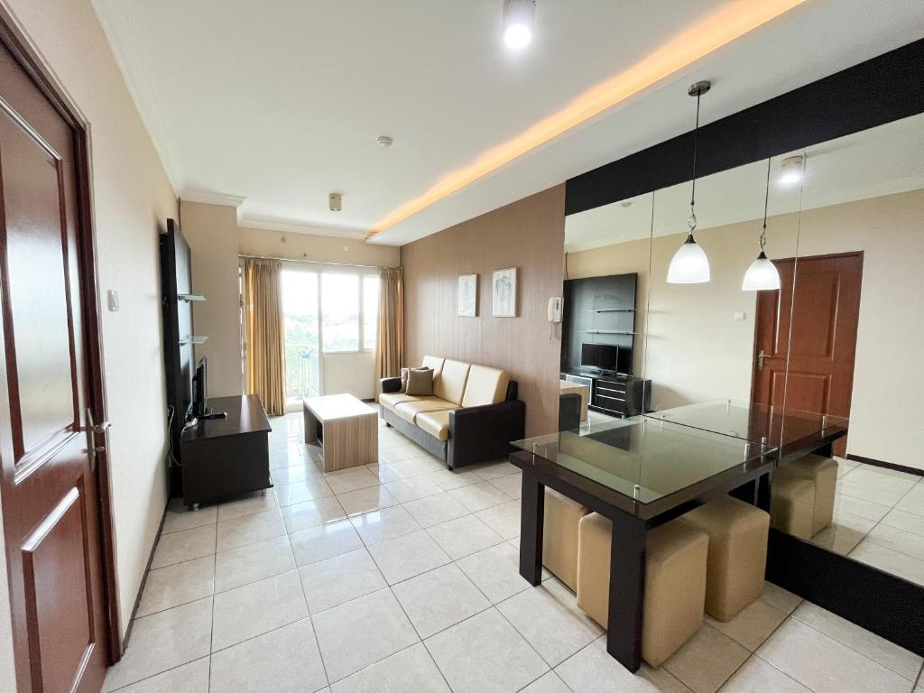een woonkamer met een bank en een tafel bij Galeri Ciumbuleuit Apartment 1 2BR 1BA - code 12B in Bandung