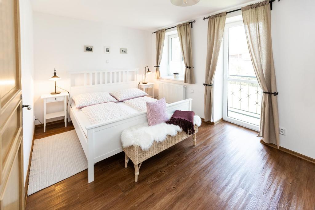 biała sypialnia z łóżkiem i krzesłem w obiekcie Penzion Na Fojtství w mieście Zašová
