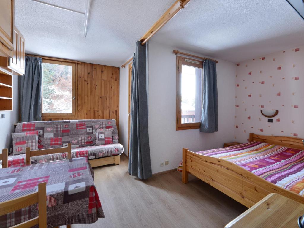 une chambre avec deux lits et une fenêtre dans l'établissement Studio fonctionnel au centre station avec balcon et vue montagne, 2 étoiles - FR-1-181-2494, à La Plagne Tarentaise