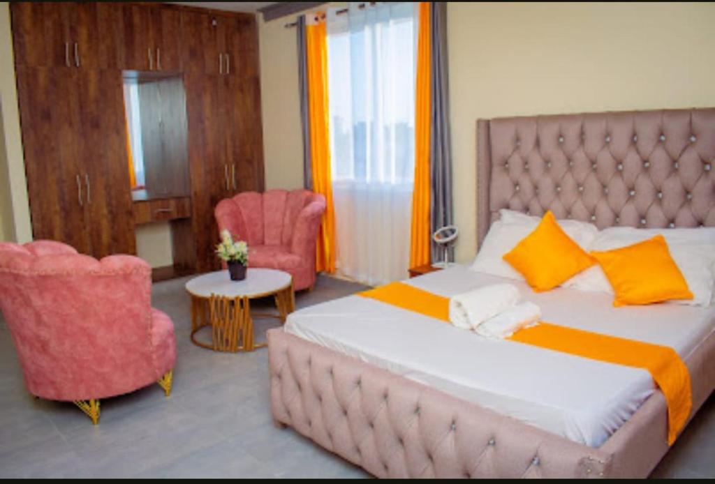 a bedroom with a large bed and two chairs at LES INTERNATIONAL in Mombasa