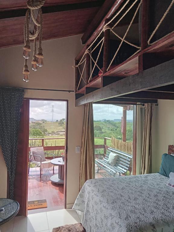 a bedroom with a bunk bed and a balcony at Chalé Adventure - Serra de São Bento RN in Serra de São Bento