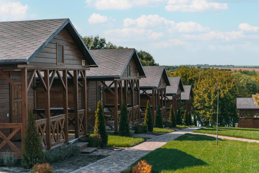 a row of wooden homes with a pathway at СИНІ ВОДИ база відпочинку 