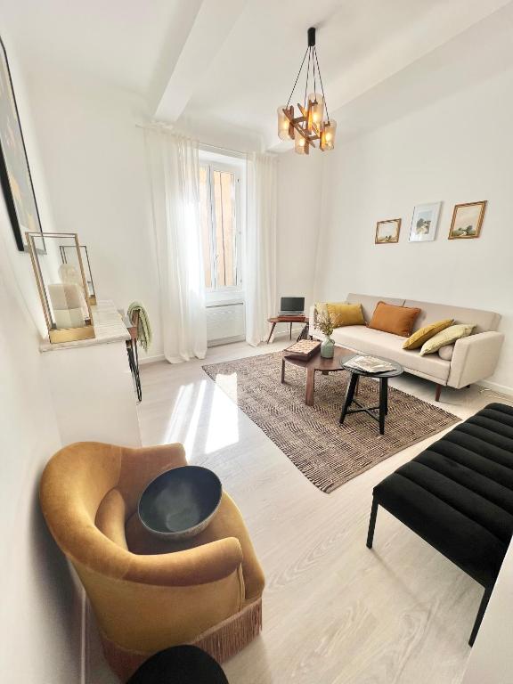 un salon avec un canapé et une chaise dans l'établissement Maison de village au calme., à Lourmarin