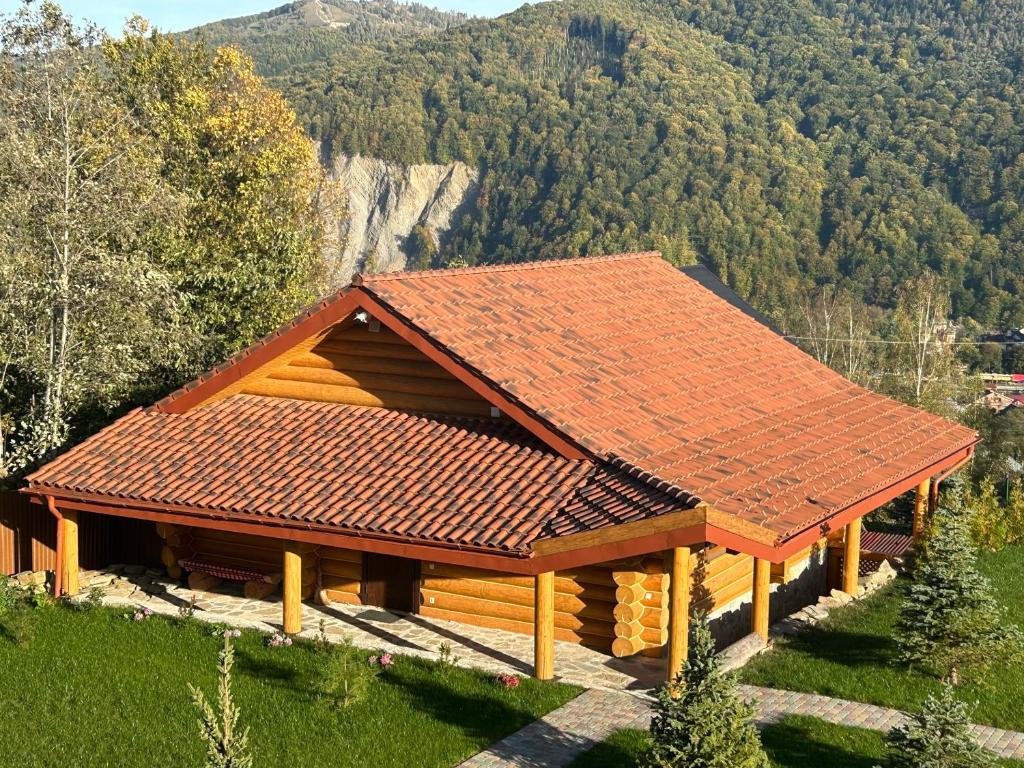 Cabaña de madera con techo rojo en una montaña en Karpaty en Yaremche