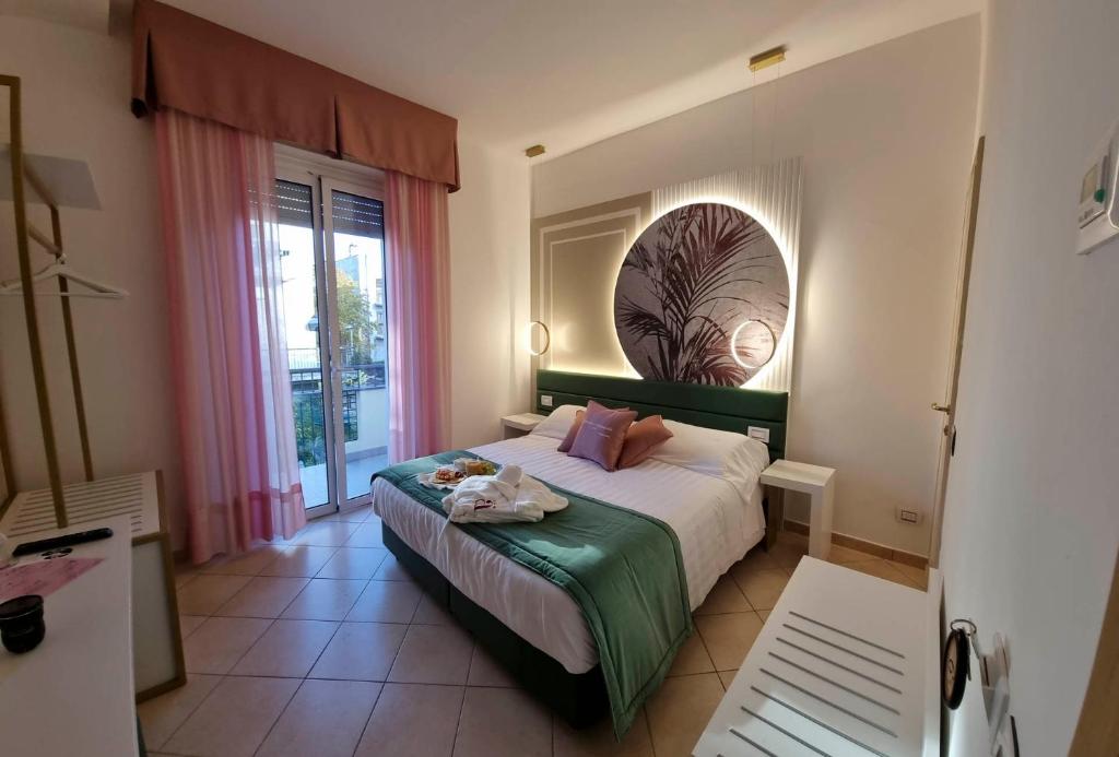 a bedroom with a bed and a large window at Hotel Angelini in Rimini