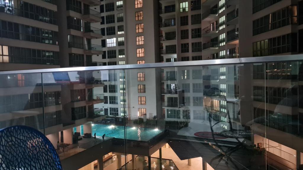 uma vista da varanda de um edifício de apartamentos à noite em Regalia Sky pool Hostel @ 969 em Kuala Lumpur