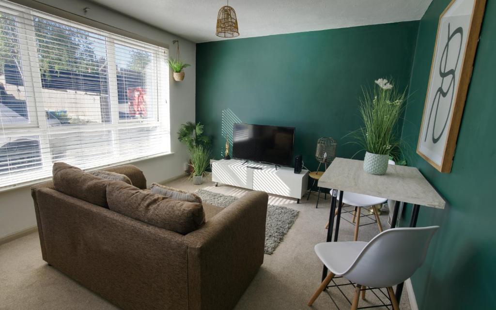 a living room with a couch and a table at #1 Limes by DerBnB, Modern 1 Bedroom Apartment, Free Parking, WI-FI & Netflix Near Royal Derby Hospital in Derby