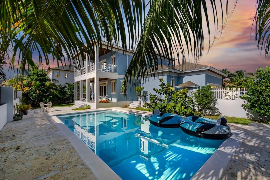 a villa with a swimming pool and a house at Blu Diamond Luxury Estate Home in Nassau