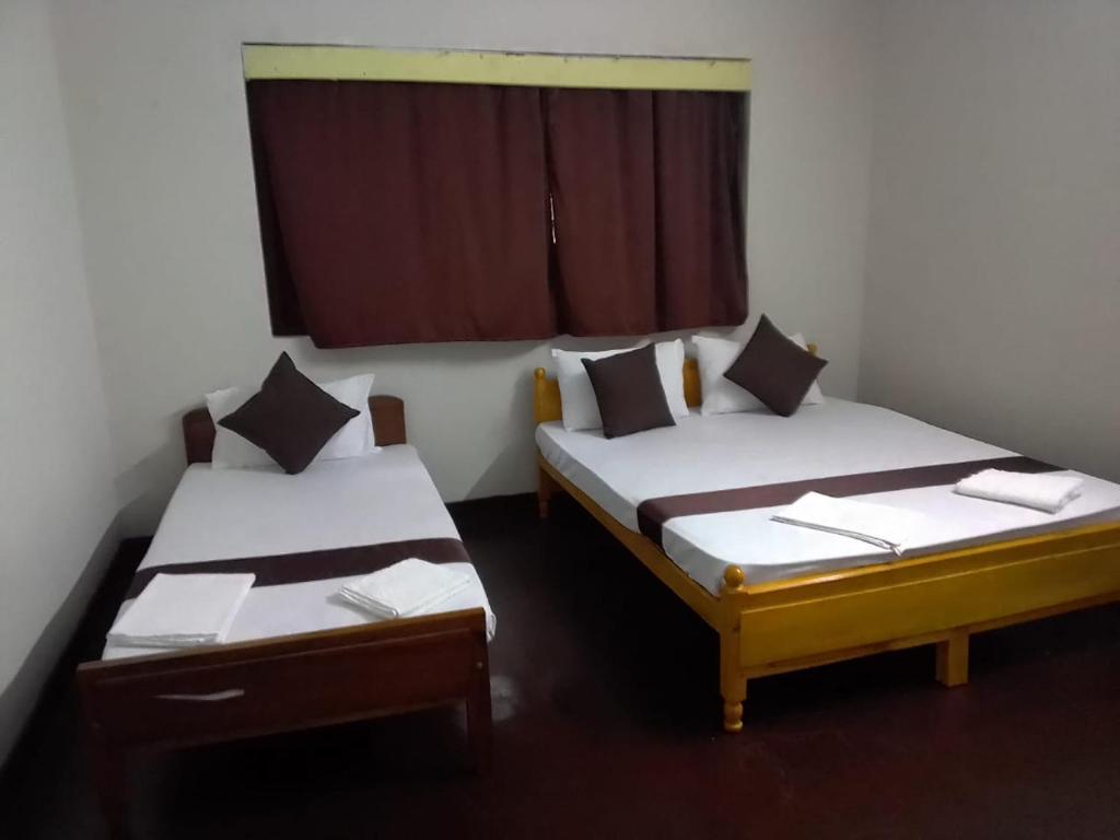 two twin beds in a room with a window at MercuryFM 104 House Colombo 8 - Mangala Road 3-1 in Colombo