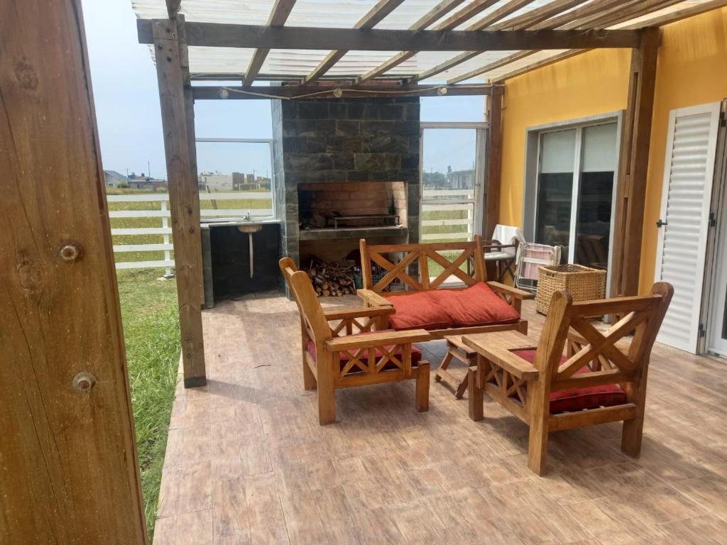 a patio with a table and chairs and a fireplace at Casa vacaciones Camet Norte in Camet Norte