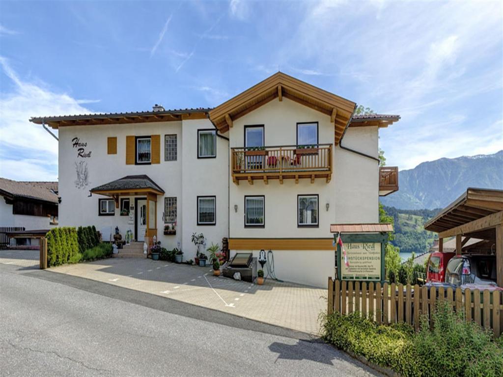 Une grande maison blanche avec balcon est située dans une rue. dans l'établissement Haus Riedl, à Seeboden