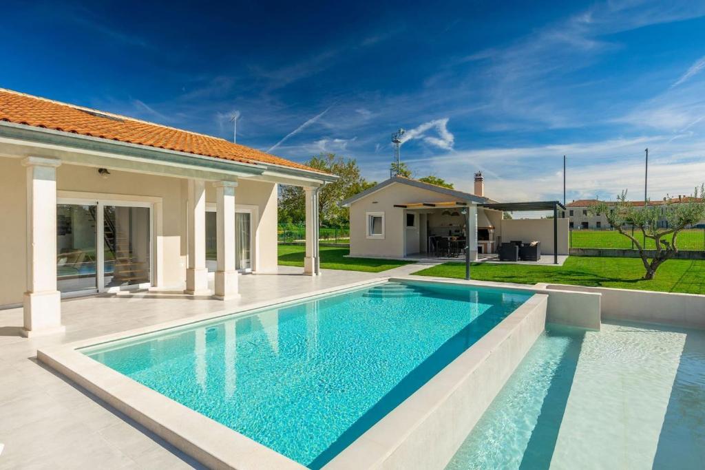 a swimming pool in the backyard of a house at Villa Civitan with infinity pool in Novigrad in Nova Vas