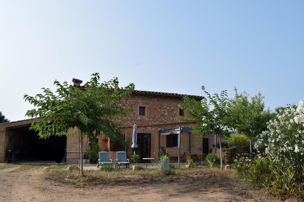 un edificio con dos sillas delante en Sa Riba, Country house in Mallorca, en Son Carrió