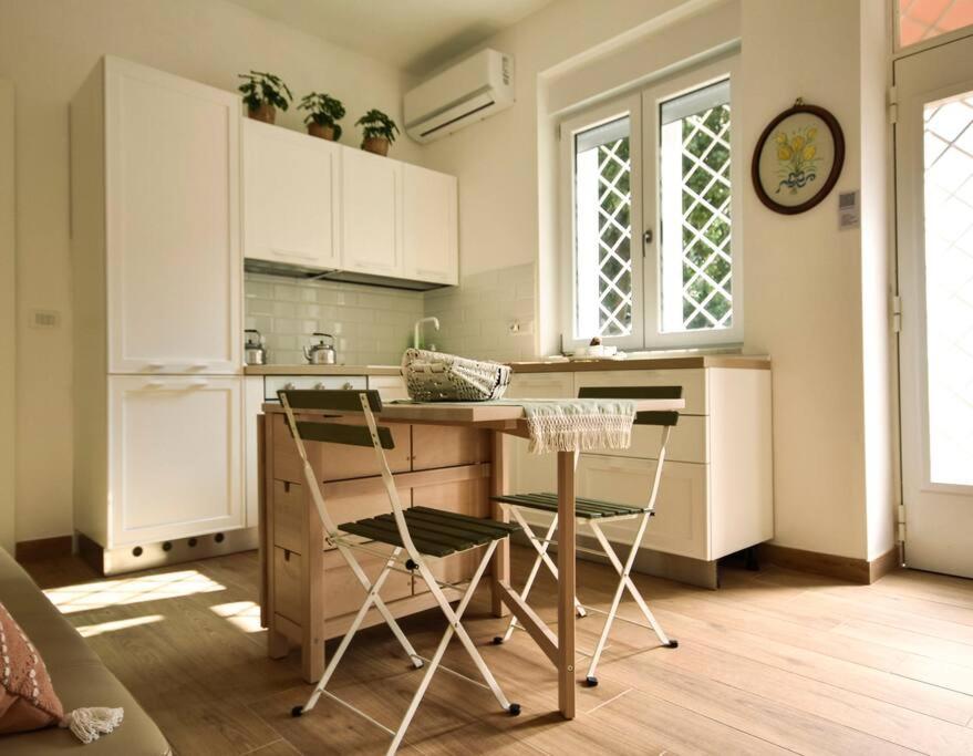 una cocina con mesa y 2 sillas. en [Double Free Parking] Anna Verrà Cottage, en Marano di Napoli